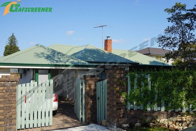 A house with a green roof and a sign that says the leafscreener
