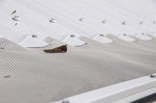 A close up of a gutter on the roof of a house.