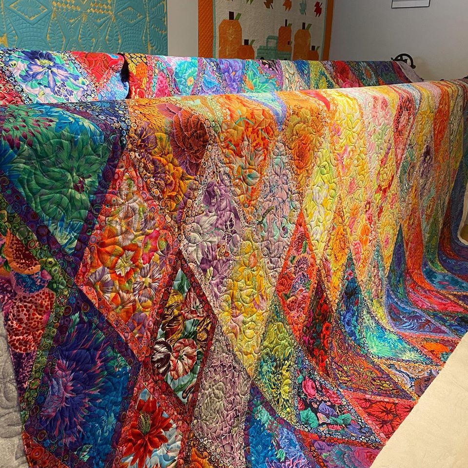 A colorful quilt is sitting on a table in a room