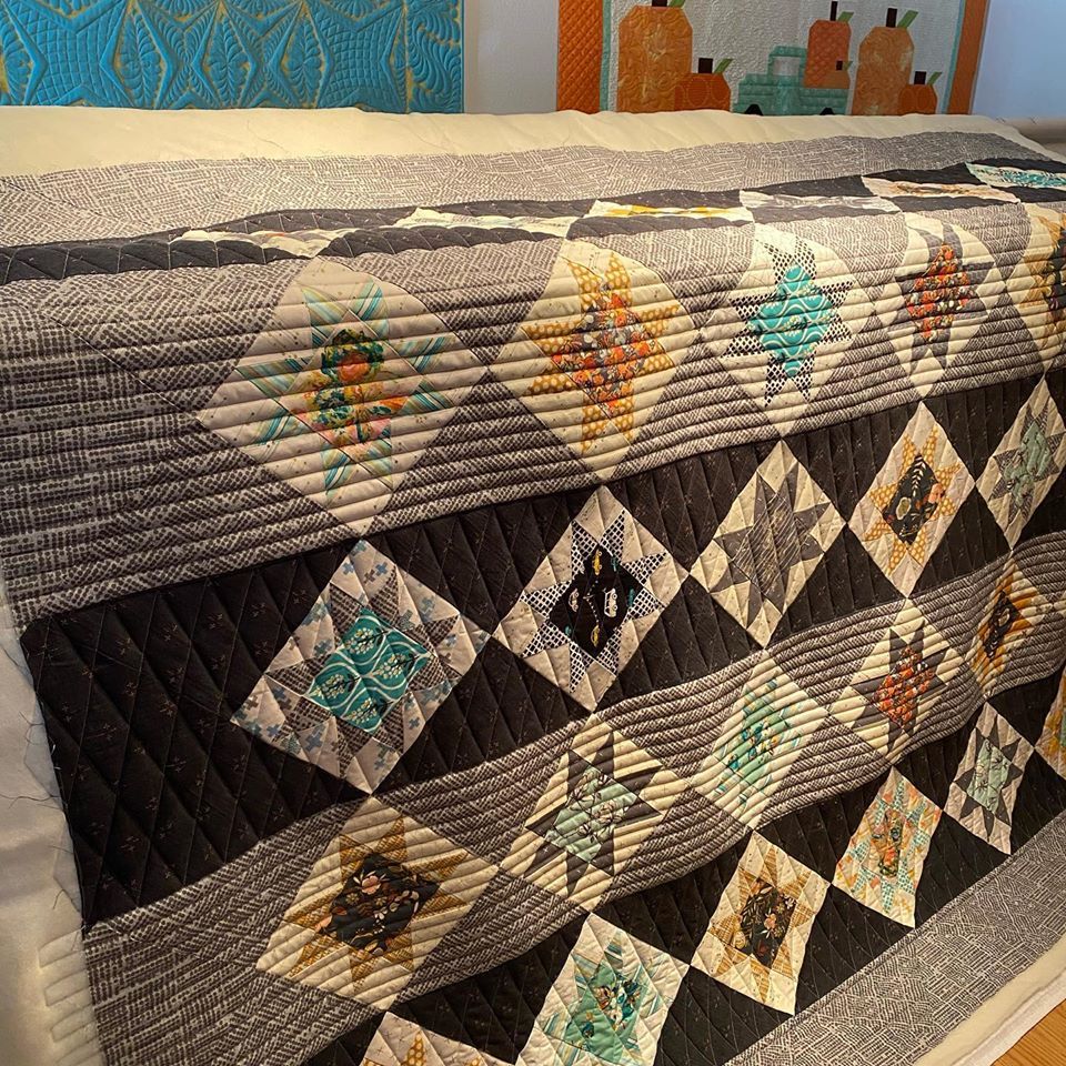 A black and white quilt is sitting on a bed