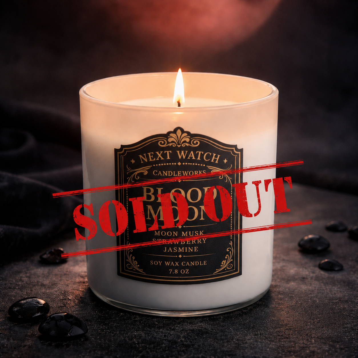 Lit white candle with black label and red “SOLD OUT” stamp on a dark surface with coffee beans