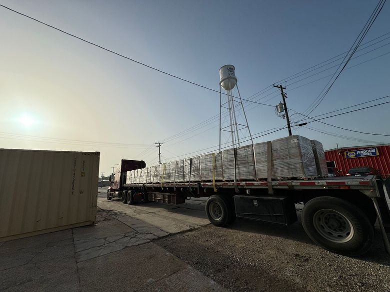 A semi truck with a water tower in the background