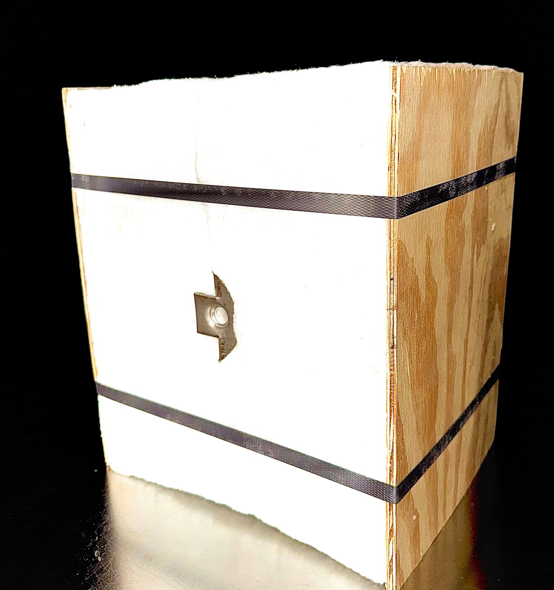 A wooden box with a black ribbon around it.