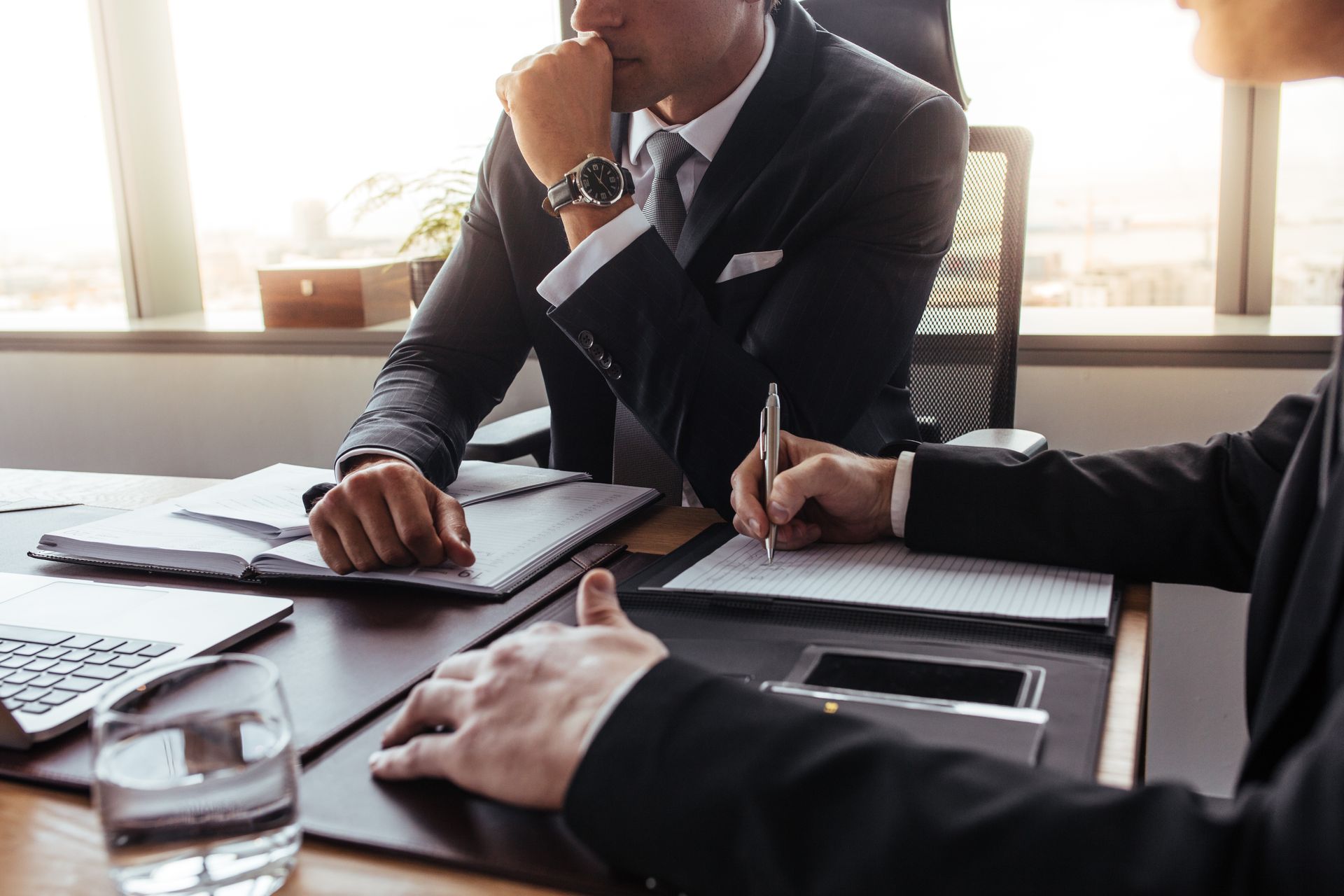 Business meeting with people reviewing documents at a conference table in a bright office.