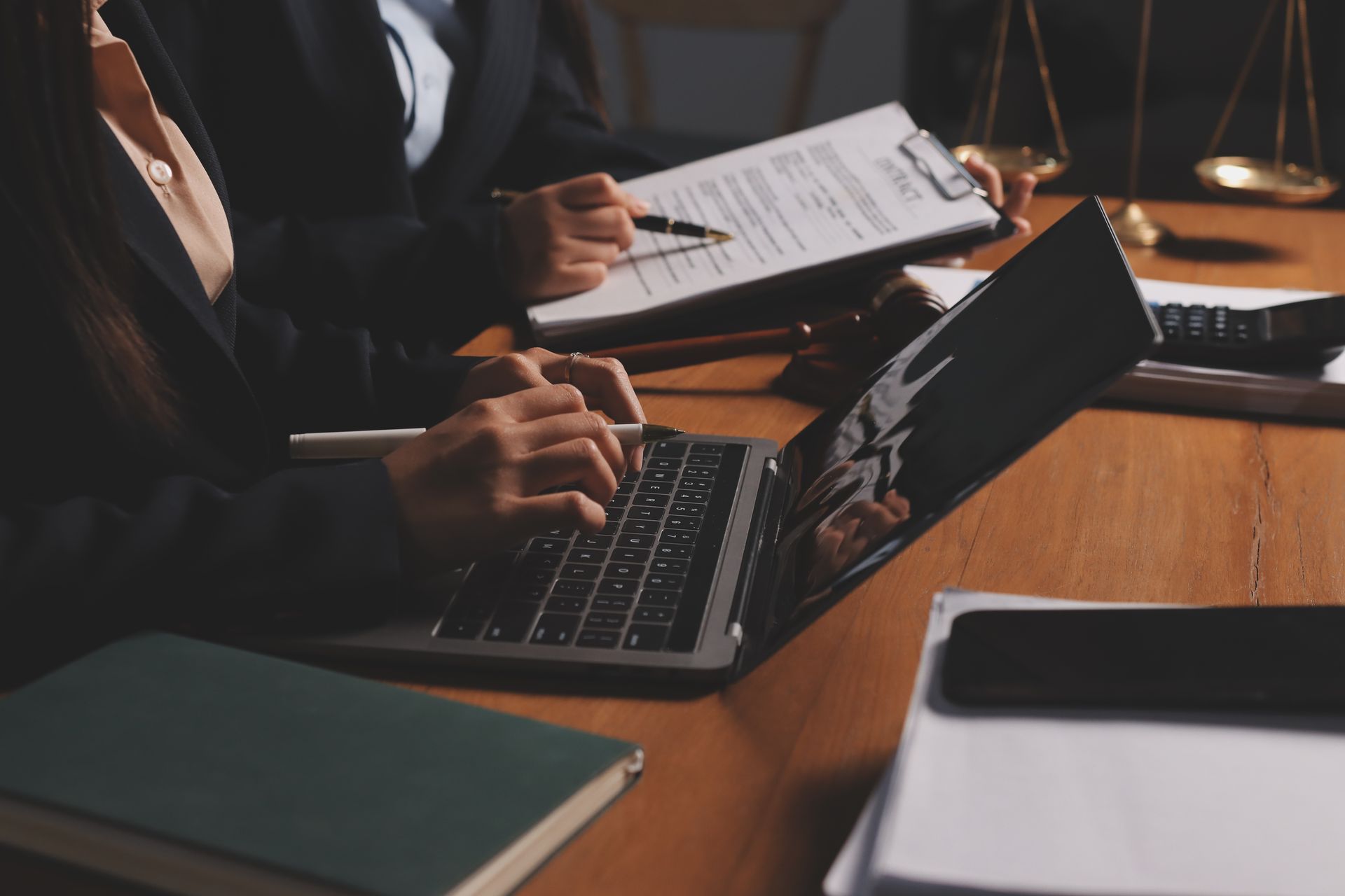 People working at a desk with a laptop.