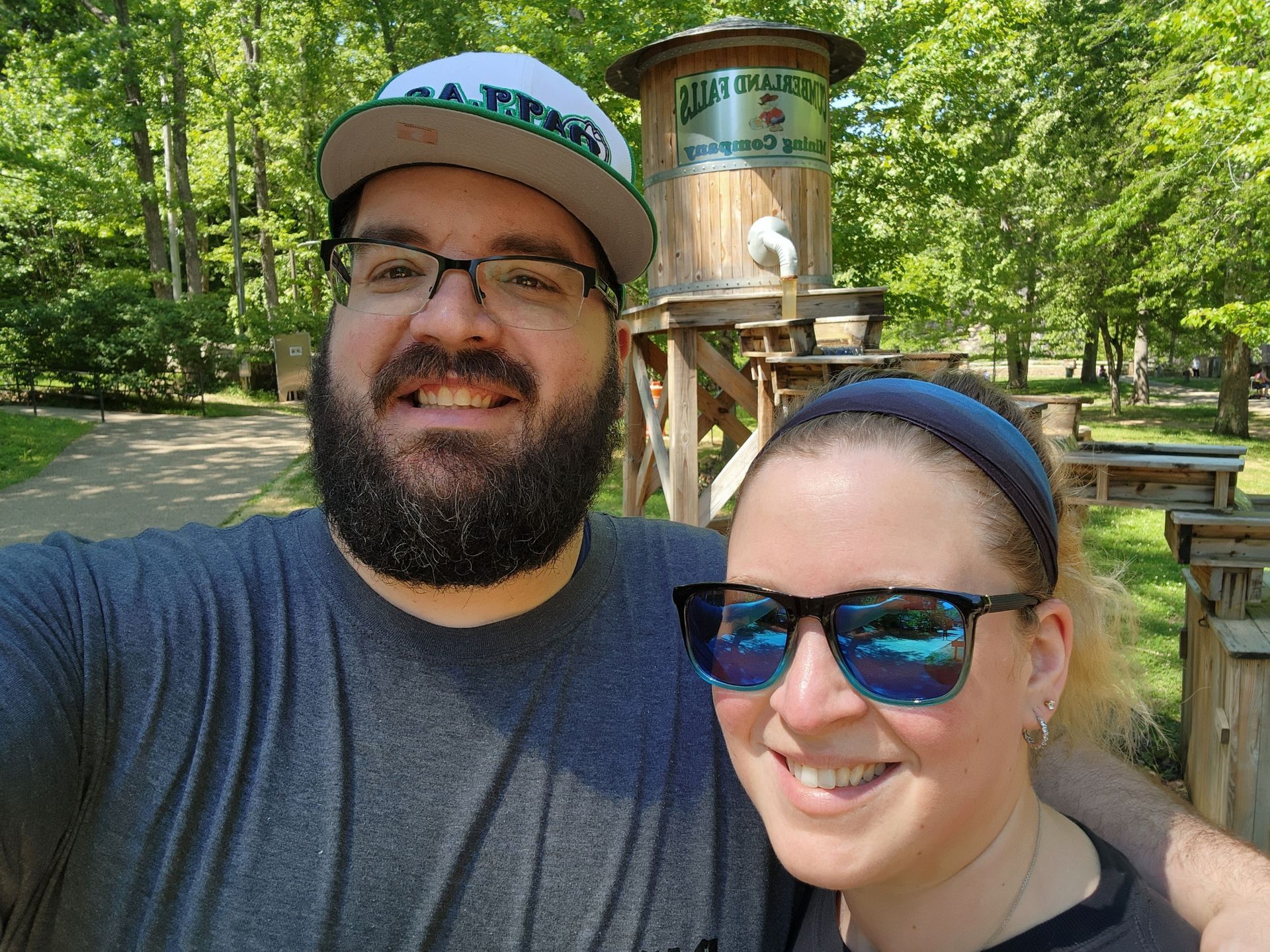 A man and a woman are posing for a picture in front of a water tower.