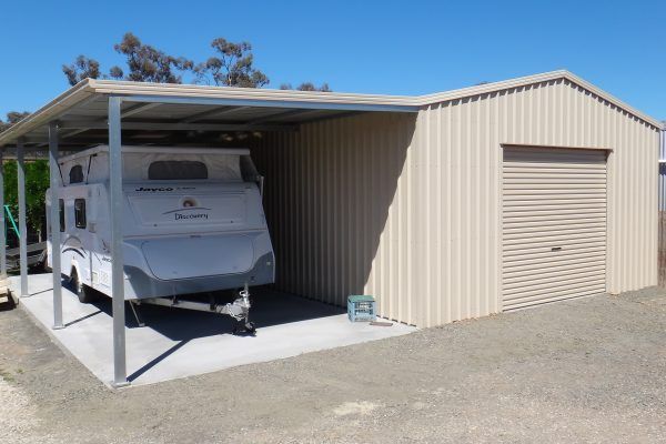 Garage with carport to side housing a caravan