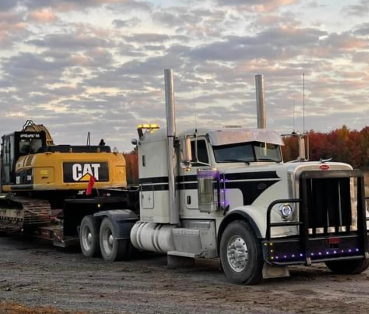 Une excavatrice à chat est attachée à l'arrière d'un semi-remorque