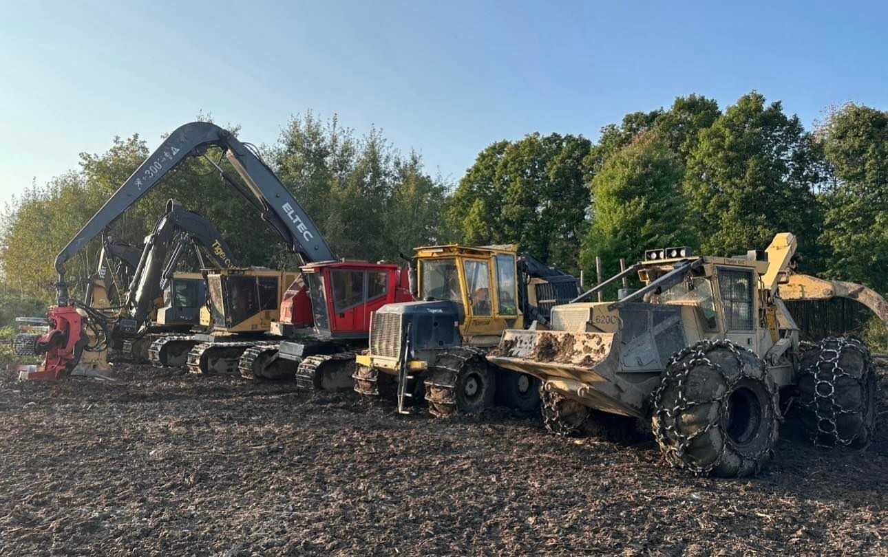 Un groupe de véhicules de construction est garé dans un champ.