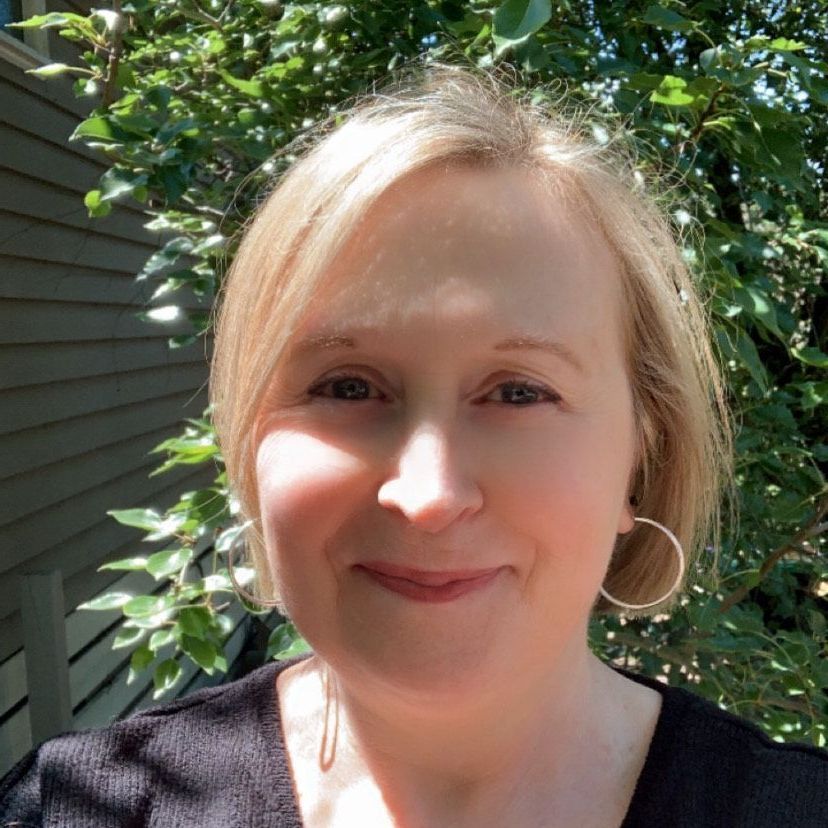 A woman with short brown hair is smiling for the camera.
