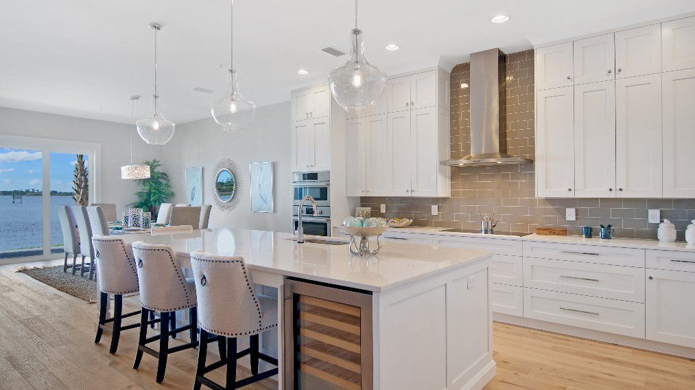 A large kitchen with white cabinets and a large island.