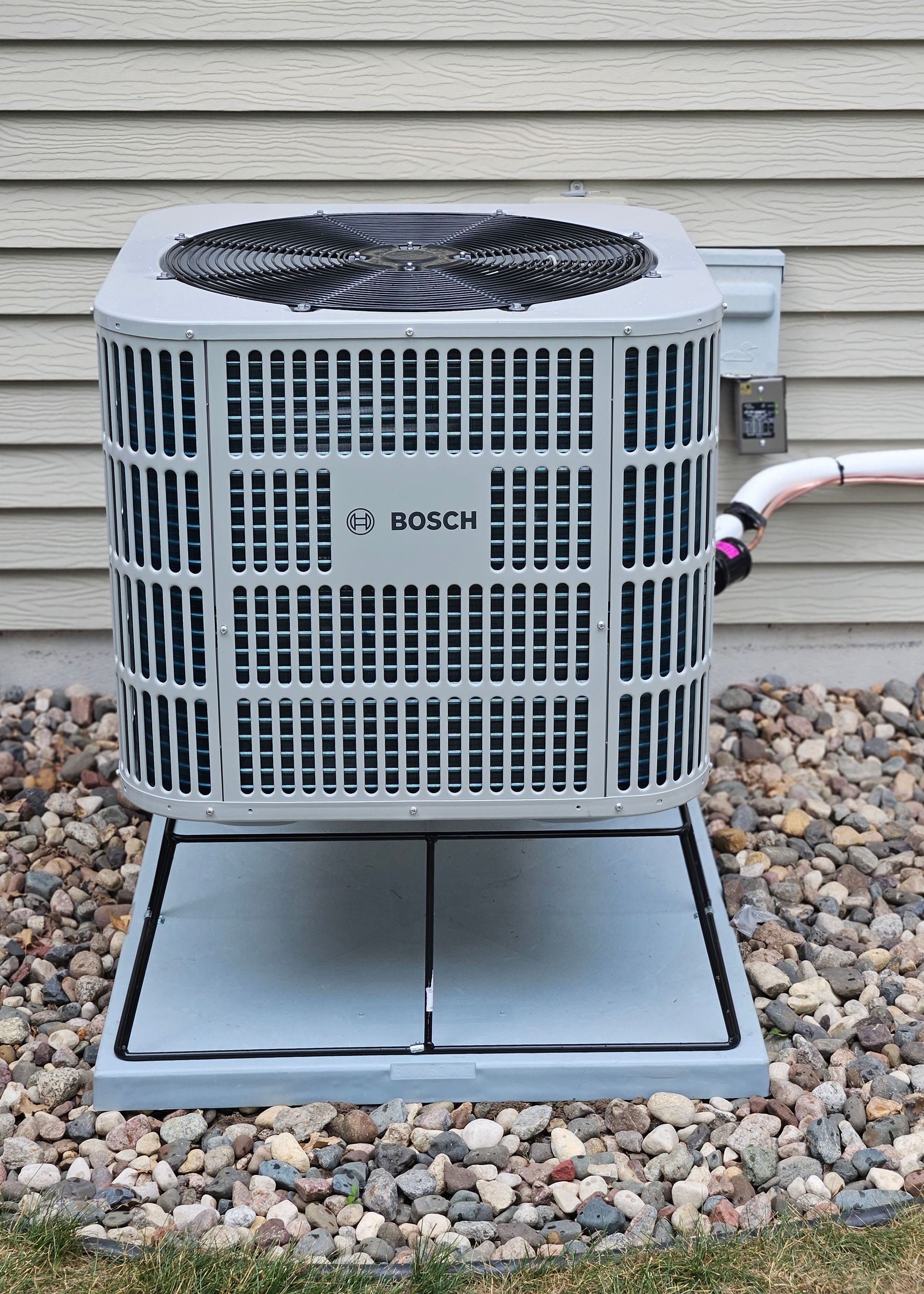 A person is cleaning an air conditioner with a blue bag.