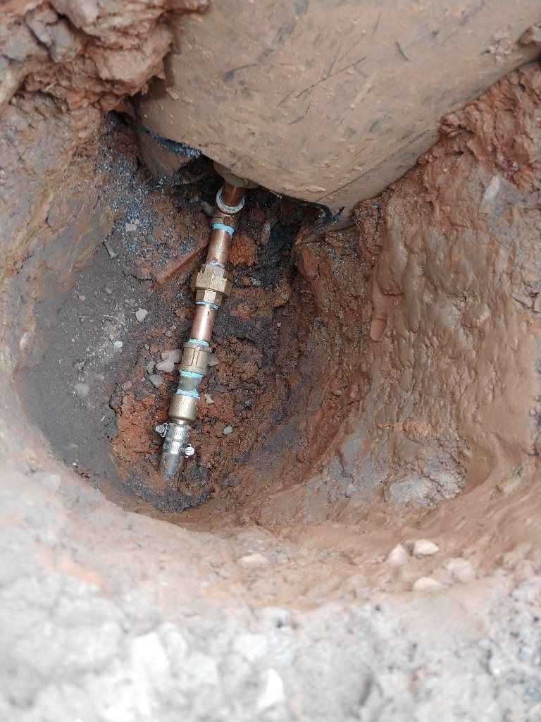 A pipe is coming out of a hole in the ground.