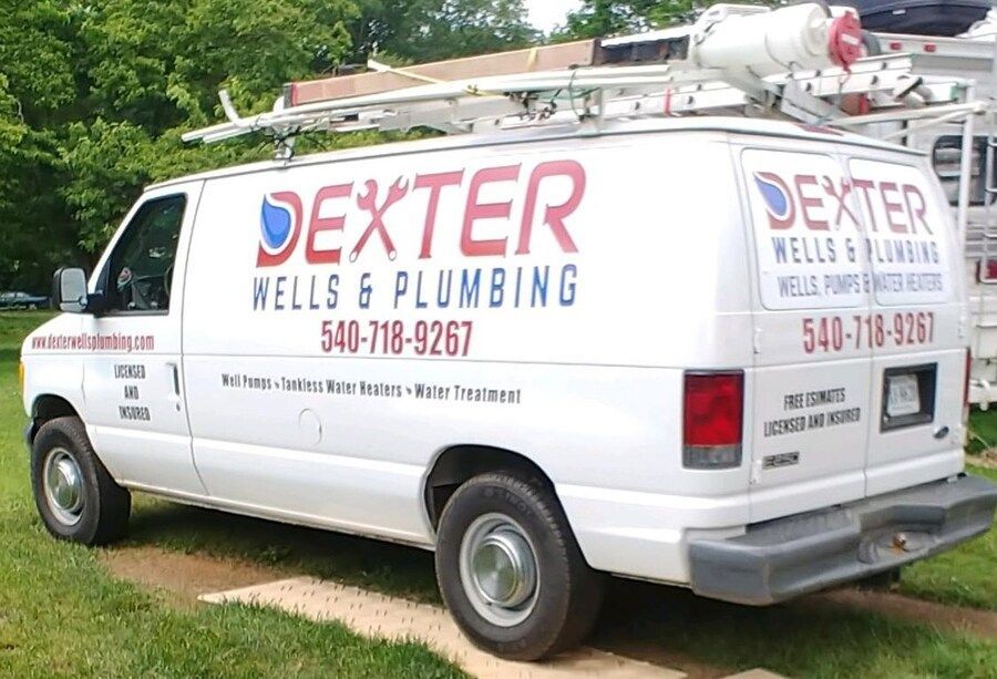 A dexter wells and plumbing van is parked in the grass