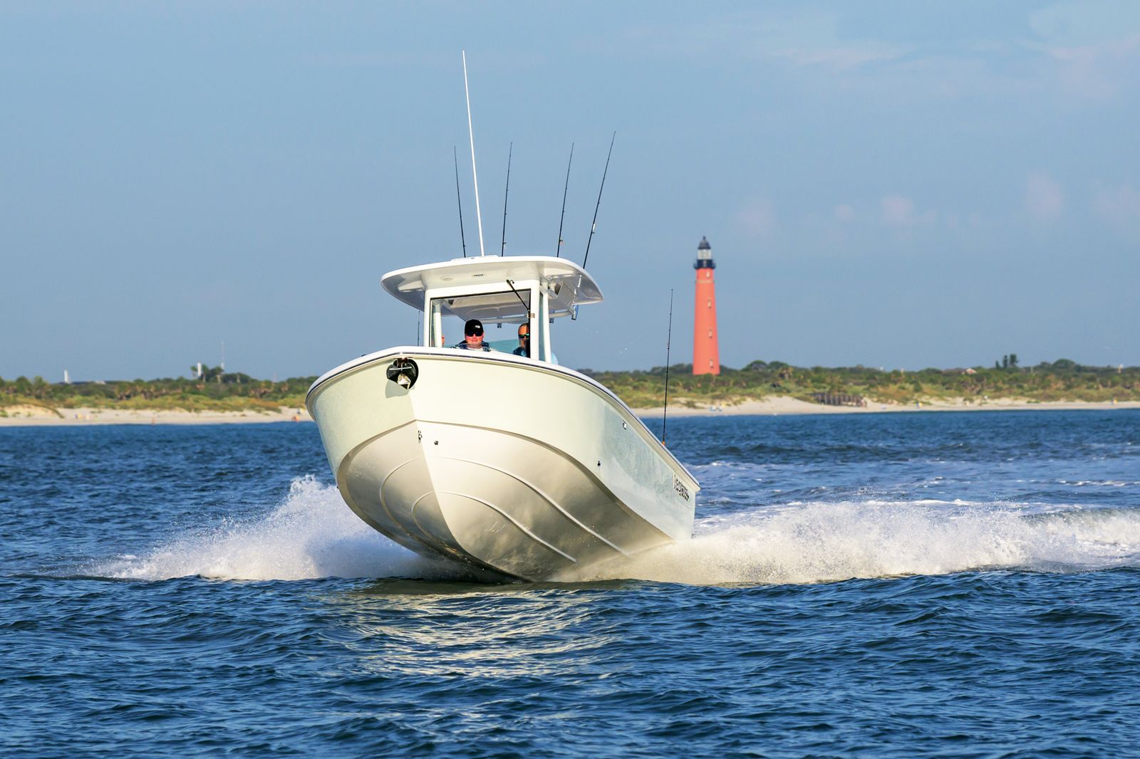 A boat is being towed by a trailer in a parking lot.