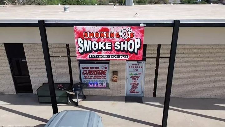 An aerial view of a smoke shop with a van parked in front of it