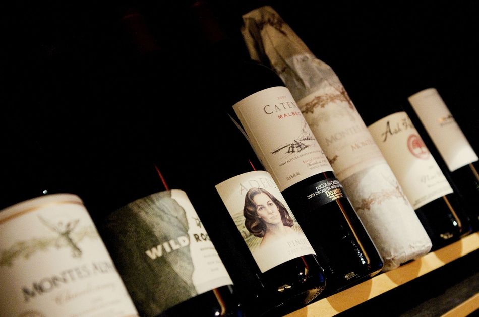 several bottles of wine are lined up on a shelf