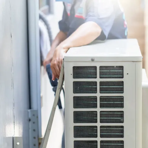 HVAC technician installing an air conditioning unit outdoors.