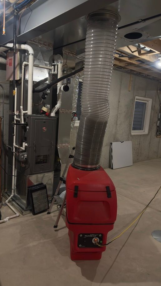 HVAC technician working on ductwork, wearing mask and safety gear. Includes a logo of a cartoon technician in a circle.