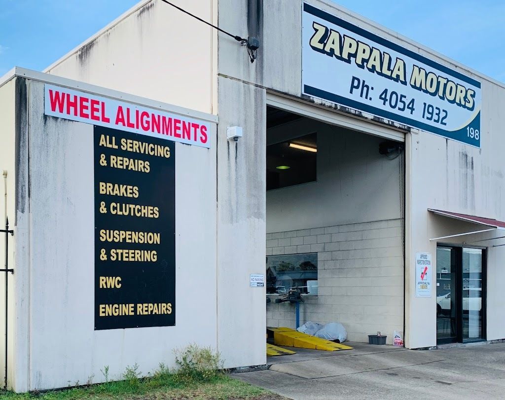 A White Building With A Sign That Says Wheel Alignments — Zappala Motors in Bungalow, QLD