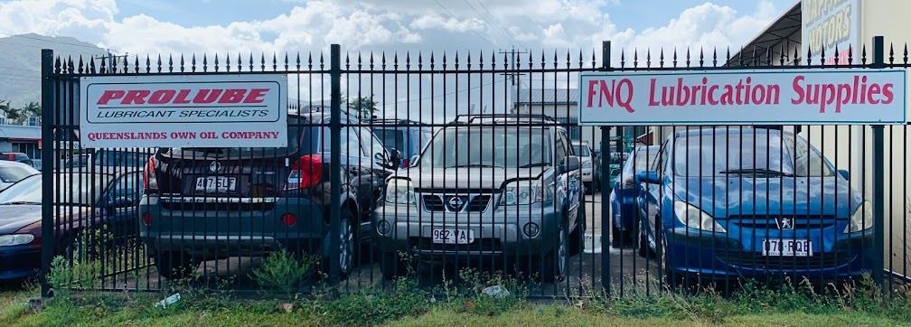 A Fence With Cars Parked In Front Of It And A Sign That Says PNQ Lubrication Supplies — Zappala Motors in Bungalow, QLD
