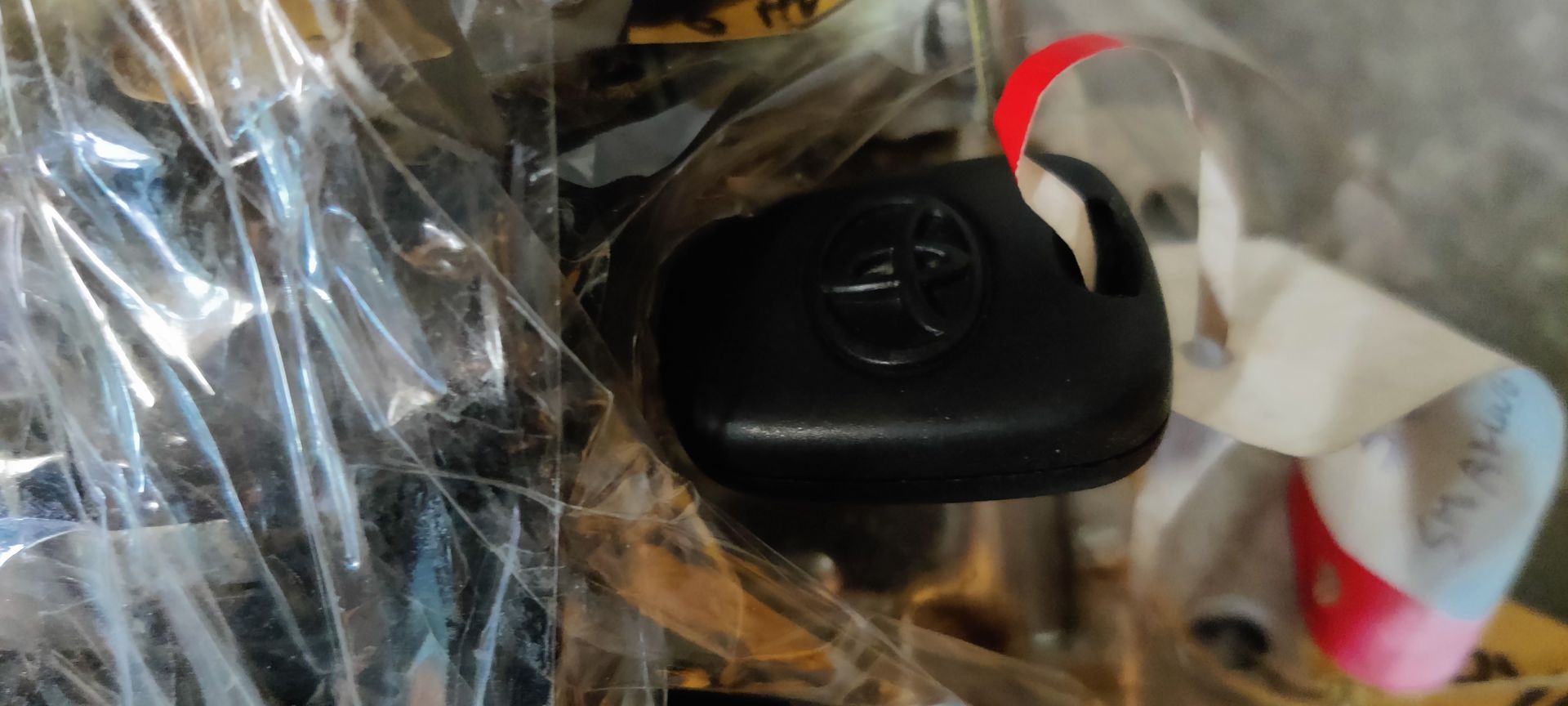 Een actuatoreenheid voor het vergrendelen van een autodeur, met een kunststof behuizing en draadconnectoren, gemonteerd op een kleine metalen beugel.