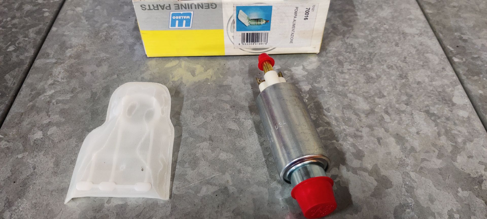 Een brandstofpomp en -filter voor auto's in een Sidat-behuizing op een grijze ondergrond.