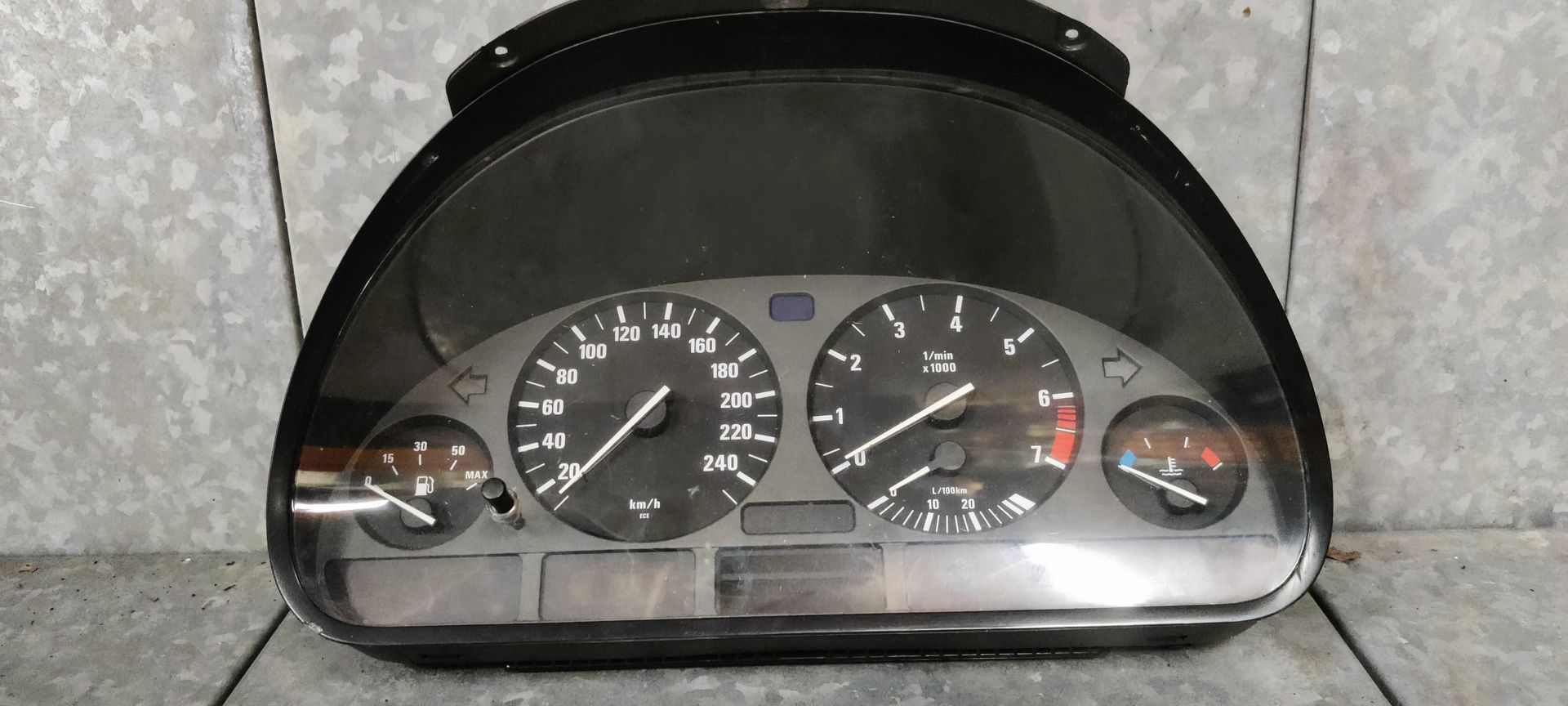 Een zwart instrumentenpaneel van een BMW E36 met snelheidsmeter, toerenteller, brandstofmeter en temperatuurmeter.