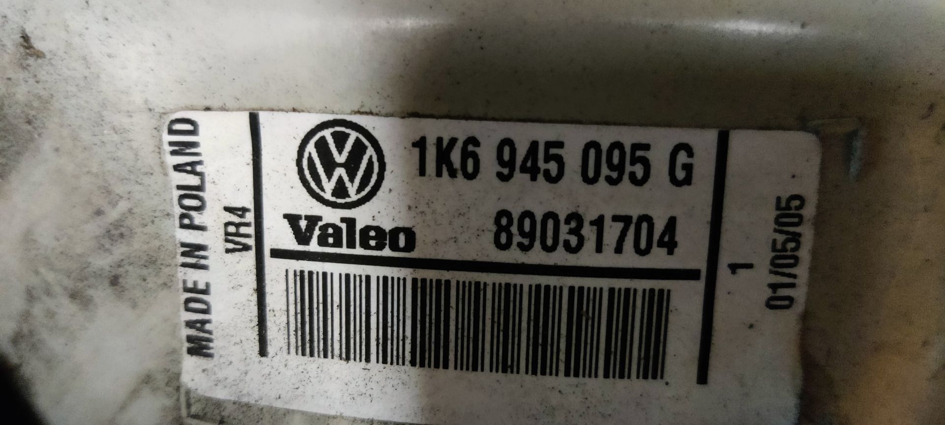 Een rode autoachterlichtunit met een centraal rond knipperlichtlens op een grijze tegelachtergrond.