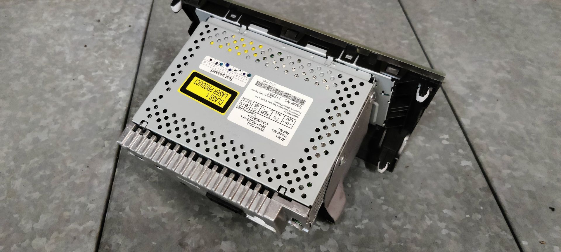 Suzuki Swift sport. Een tweekleurige autoradio en cd-speler met een beige bovengedeelte en een zwart bedieningspaneel aan de onderkant.