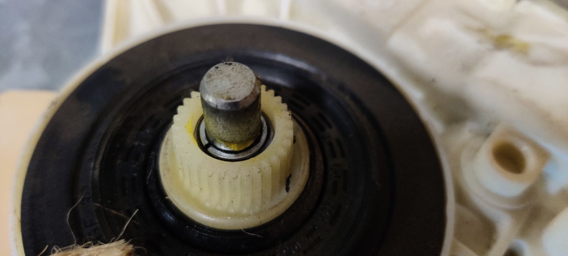 Een wit-zwart plastic raammotor voor auto's met een handgeschreven identificatielabel.