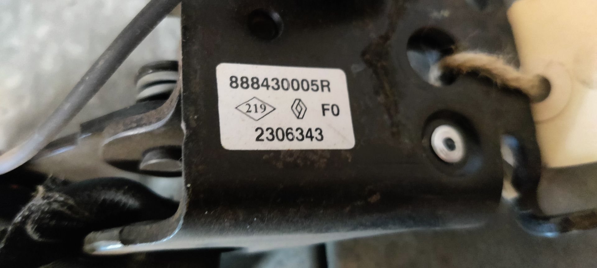 Twee zwarte bevestigingspunten voor autogordels, gemonteerd op een metalen beugel op een grijze betonnen vloer.