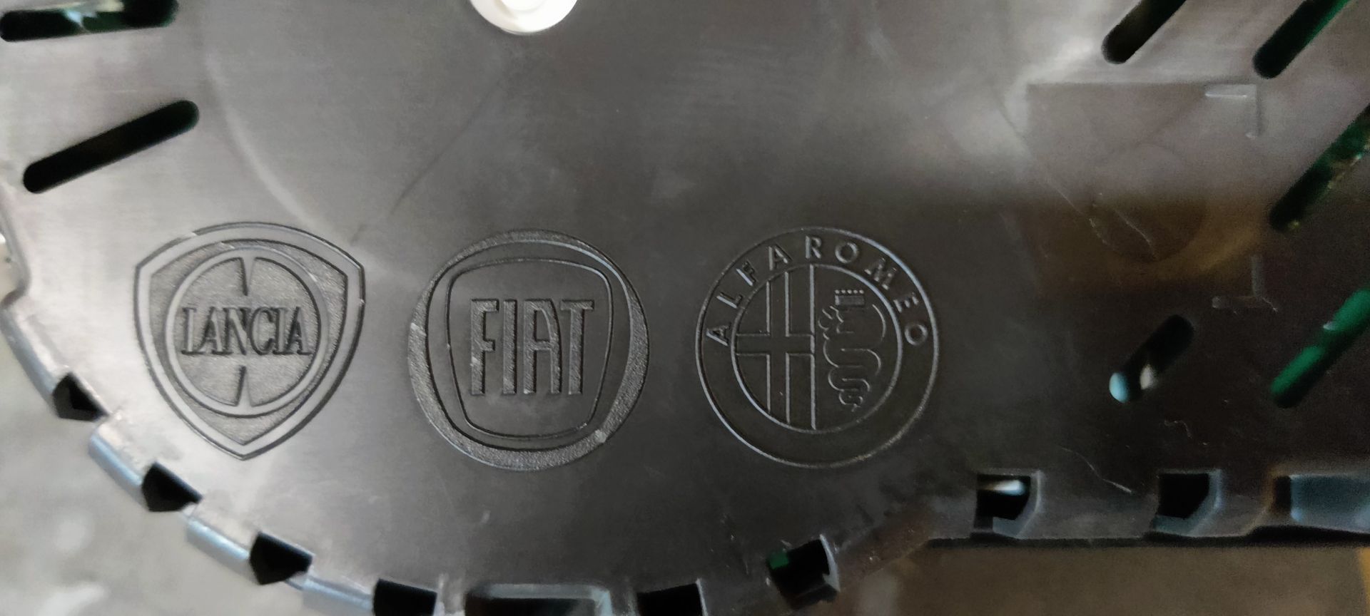 Alfa Romeo MiTo dashboard. Een zwart instrumentenpaneel voor auto's met een snelheidsmeter, toerenteller en twee kleinere meters met een geel label.