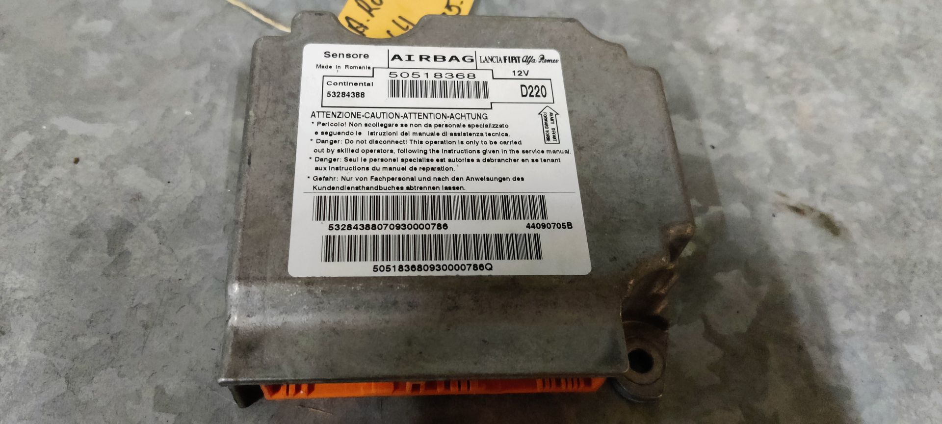 Mito airbag-regelmodule met een wit productlabel waarop barcodes en technische tekst staan, op een grijze ondergrond.