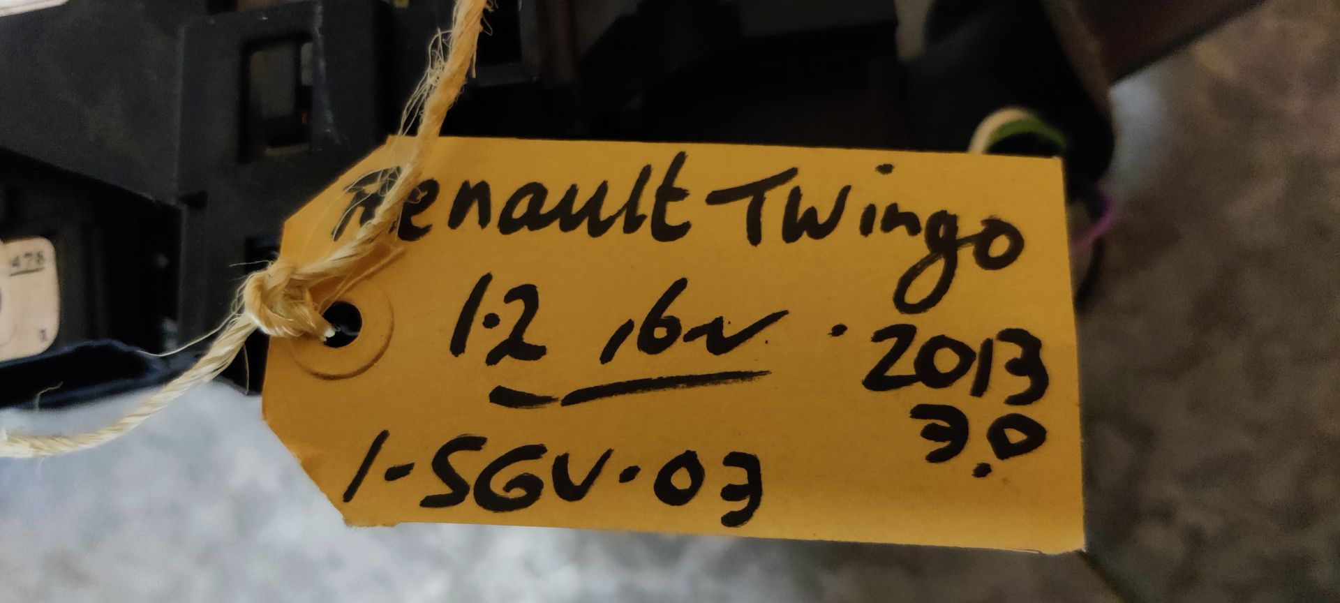 Een zwarte stuurkolomschakelaarunit voor auto's met richtingaanwijzer- en ruitenwisserhendels en een centrale klokveermodule.