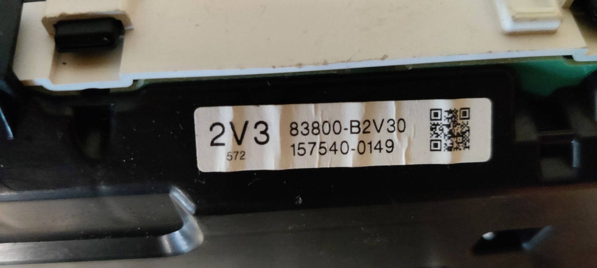 Een zwart dashboard met een snelheidsmeter, gele markeringen van 0 tot 220 km/u, een rode wijzer en een digitaal display.