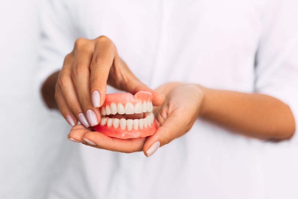 Dentist Holding A Model Of Teeth In Her Hands — Aspire Dental in Townsville, QLD