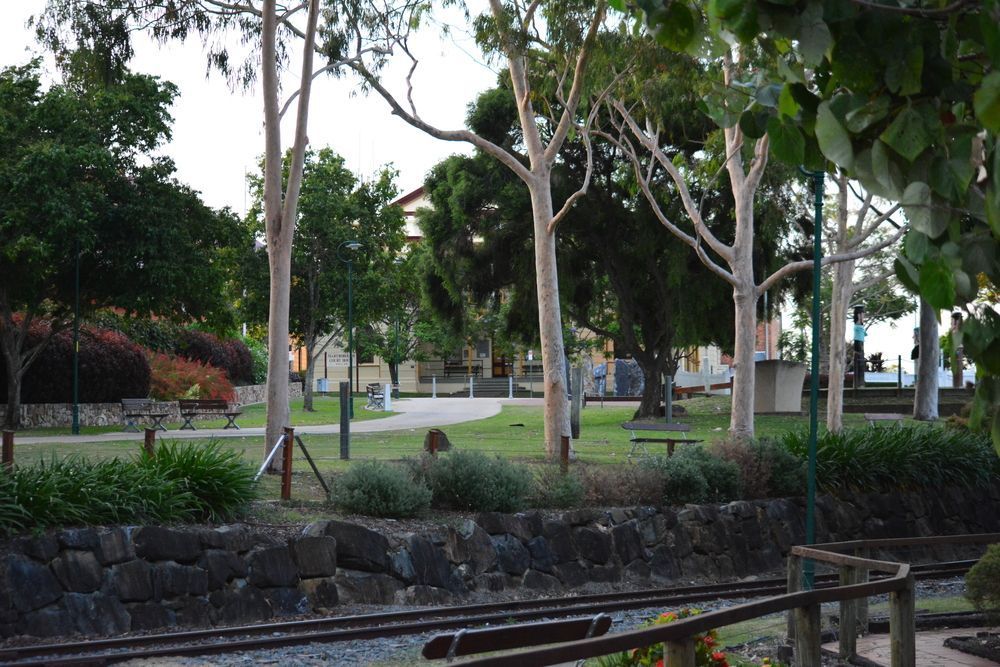 A Park With Trees And A Stone Wall In The Foreground — Aspire Dental in Condon, QLD