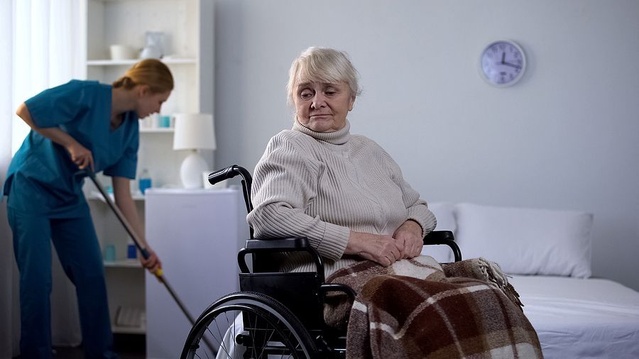 a woman in a wheel chair with a nurse in the background