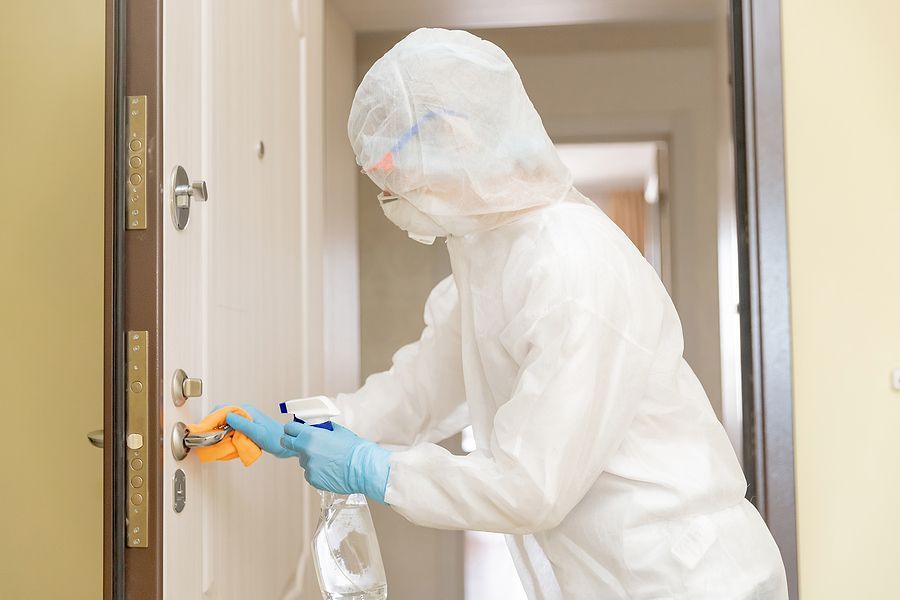 a person in a protective suit is opening a door