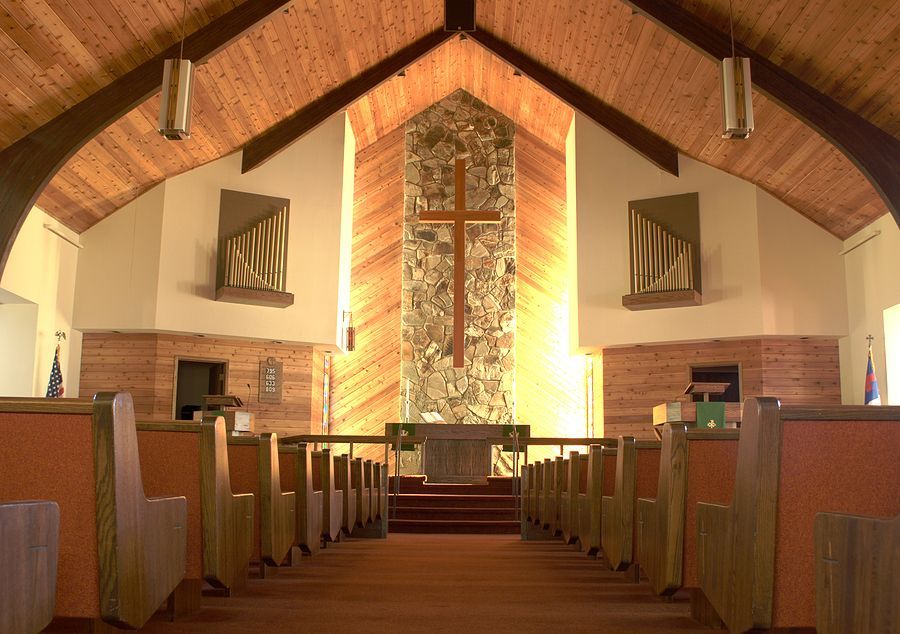 inside of a church with wooden pews