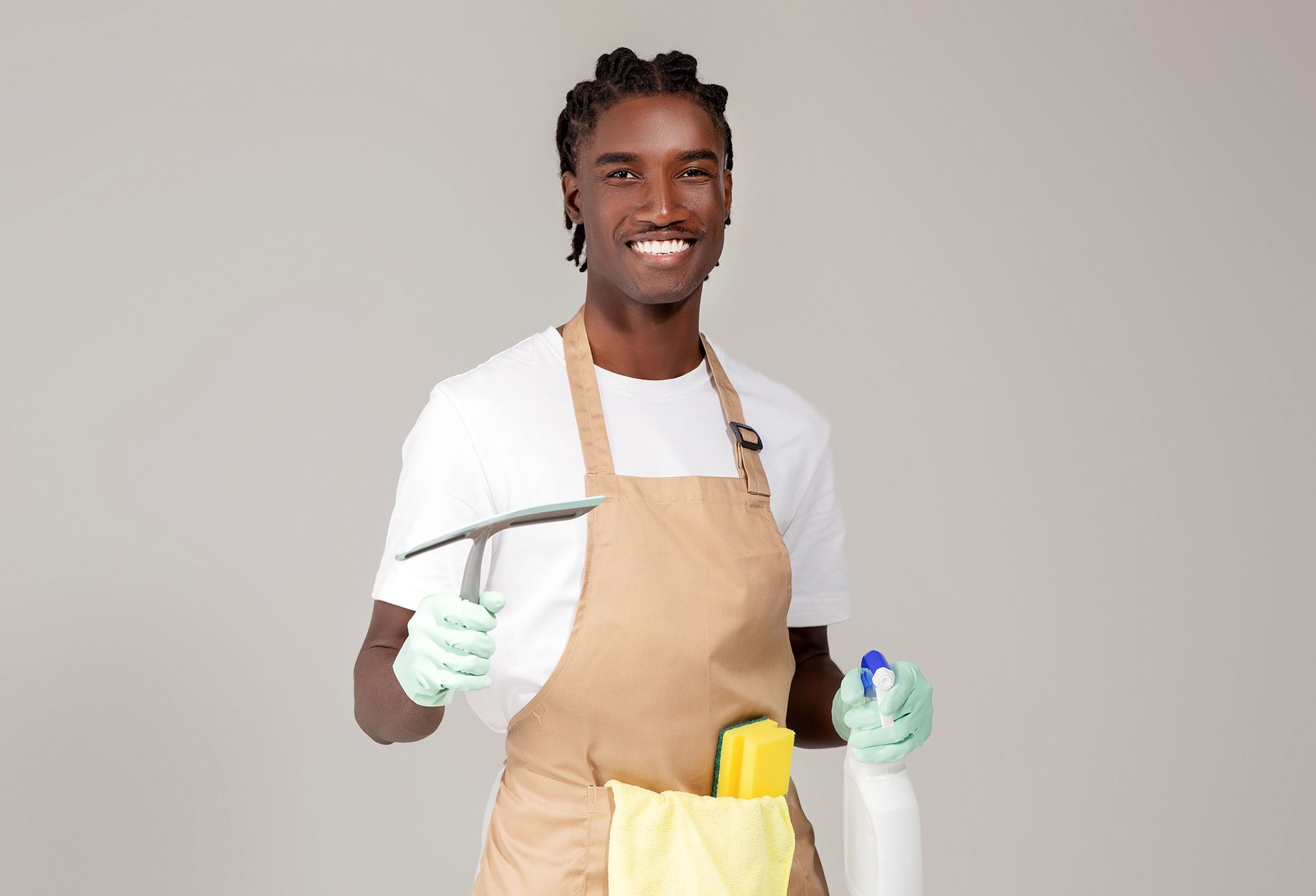 a man in an apron holding a spatula and cleaning supplies