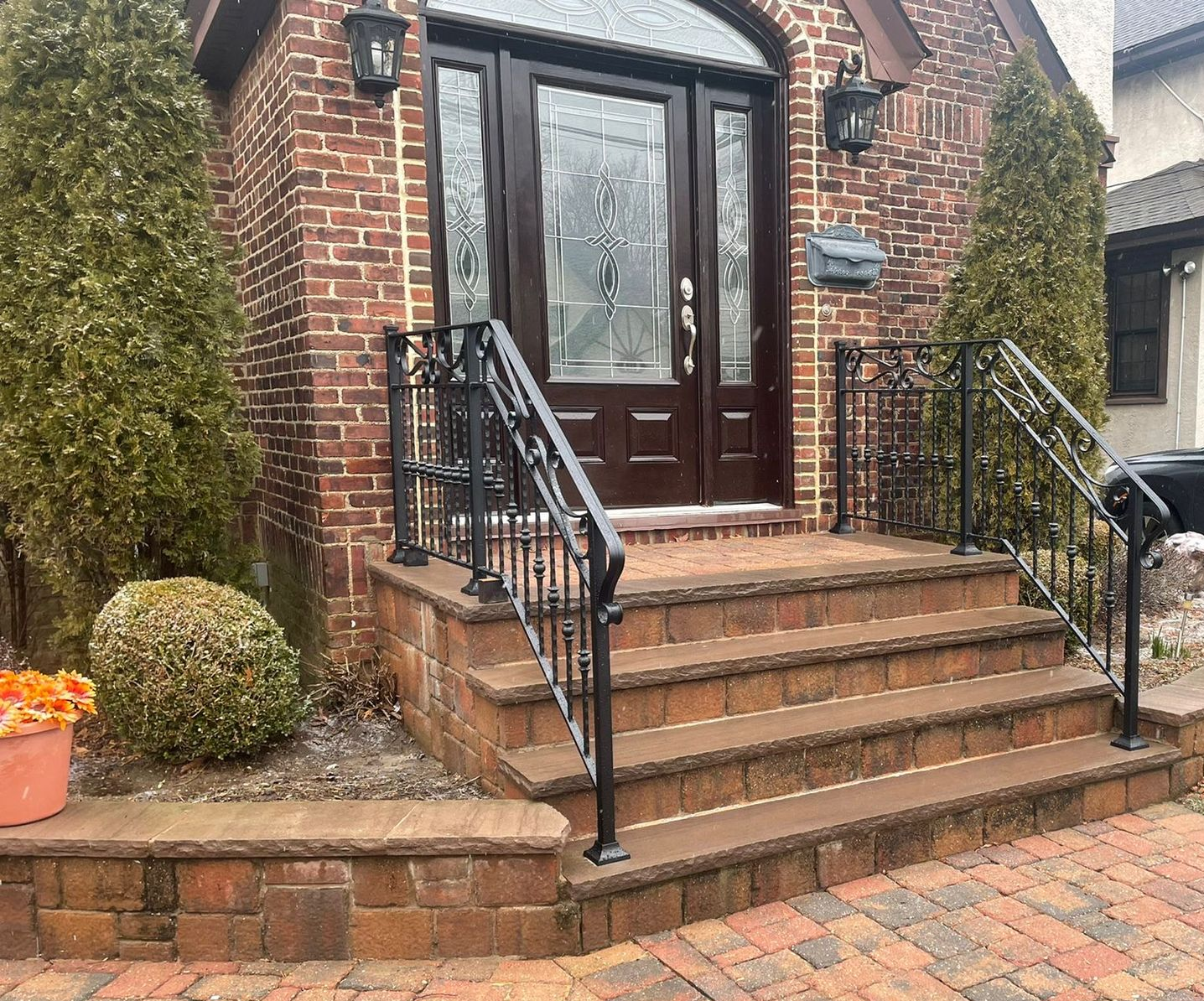 White brick house with black door, steps, and railing White brick house with black door, steps, and railing