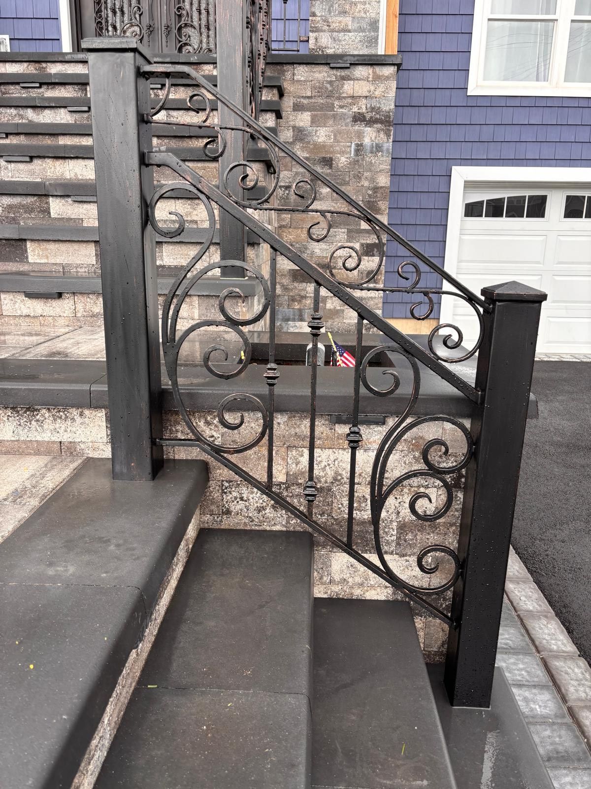 Ornate wrought-iron banister with decorative floral elements along a marble staircase Ornate wrought-iron banister with decorative floral elements along a marble staircase