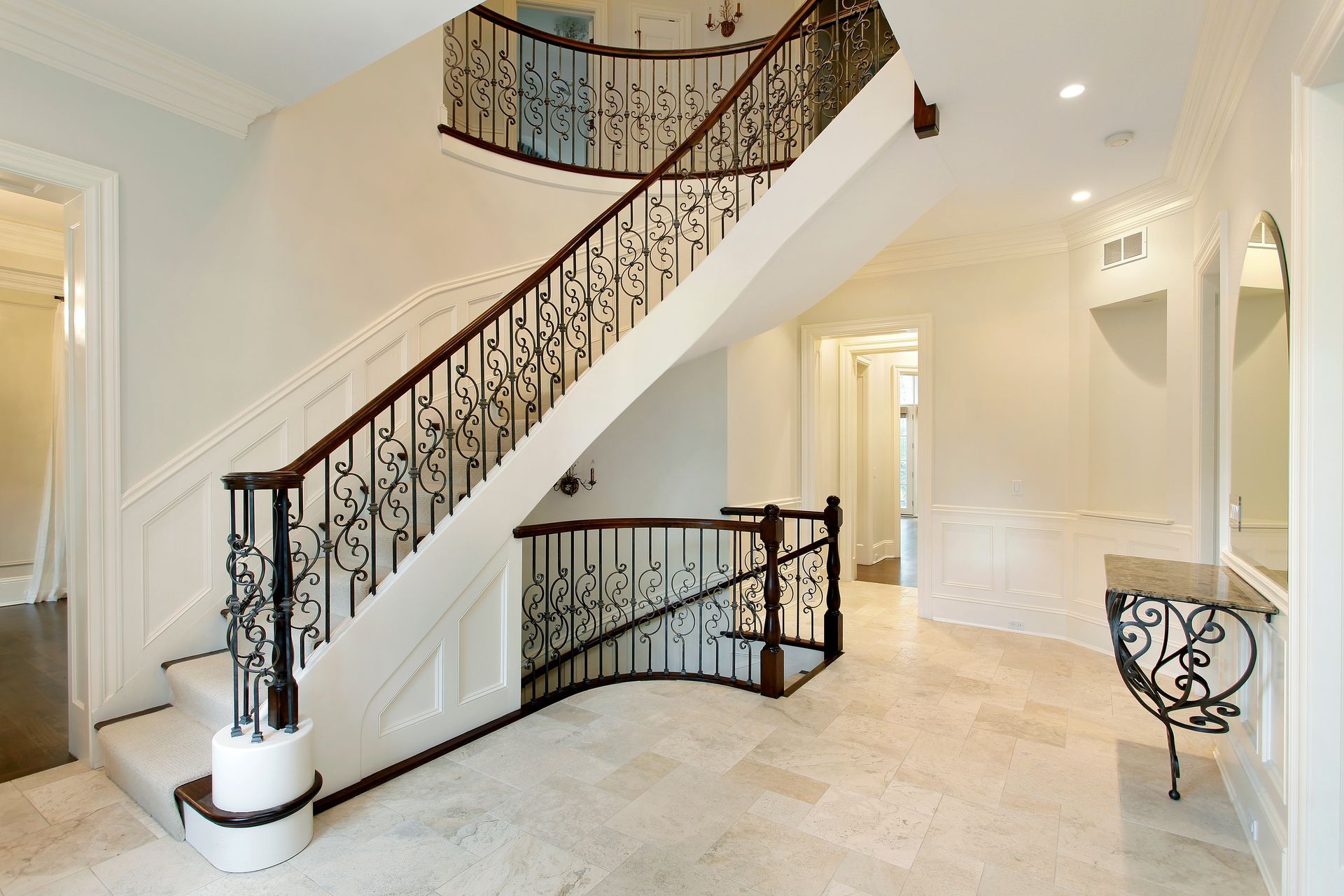 Beige tile floor, white walls, and ornate wrought-iron railing
