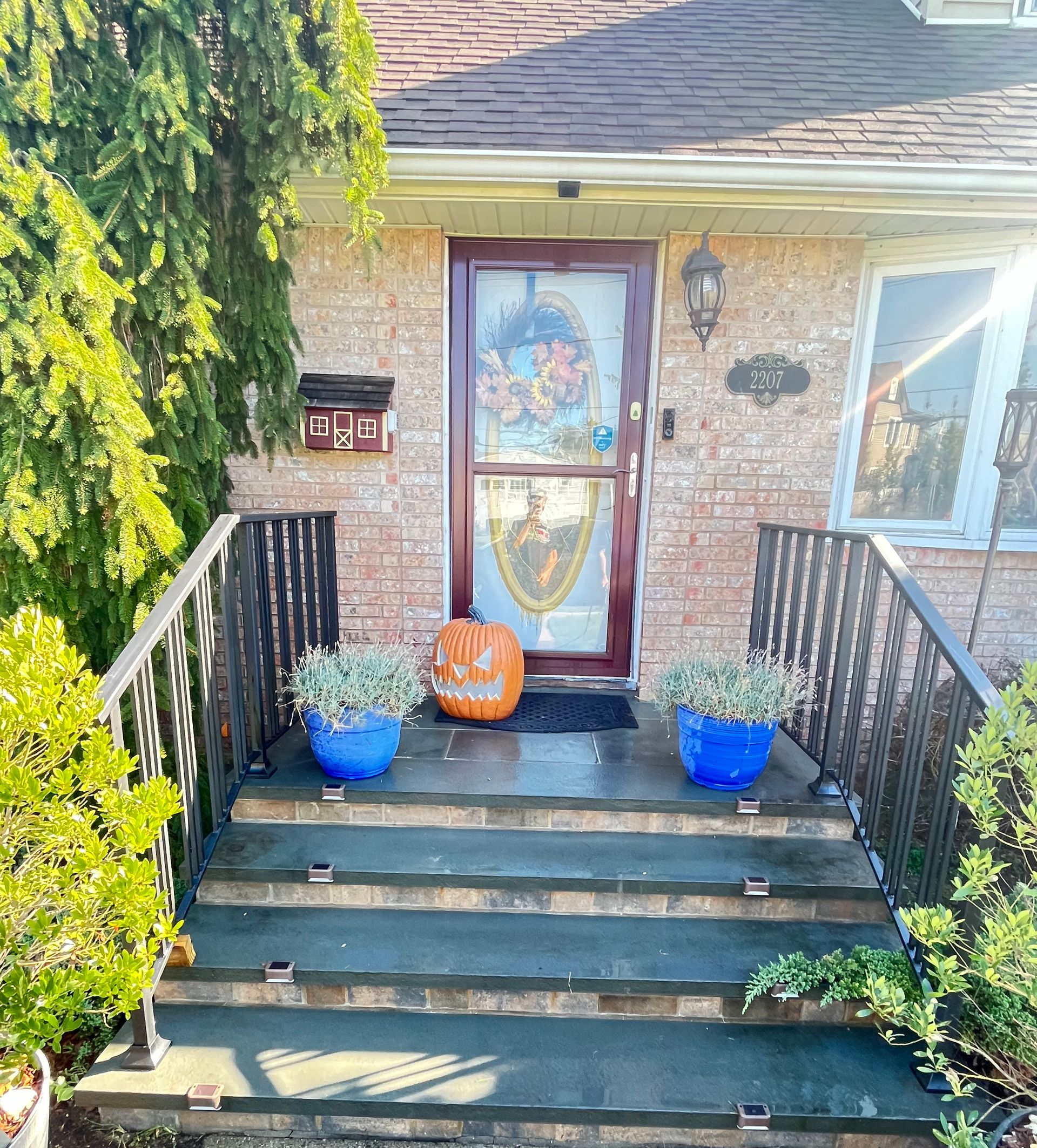 Staircase with tiled steps and metal railings, leading to a second floor with white walls and natural light Staircase with tiled steps and metal railings, leading to a second floor with white walls and natural light
