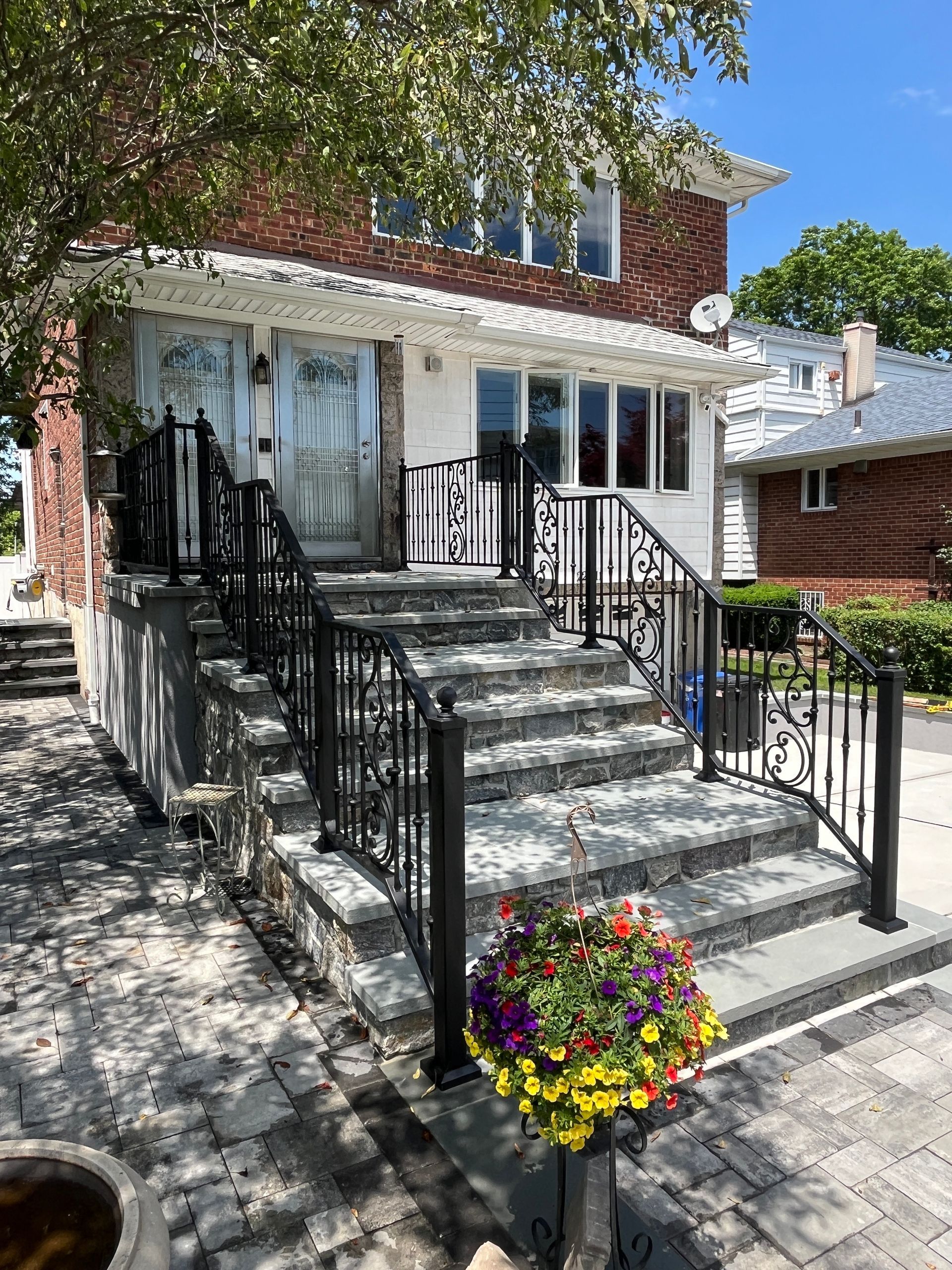 Staircase with metal handrails, textured gray flooring, and tactile paving, leading down Staircase with metal handrails, textured gray flooring, and tactile paving, leading down