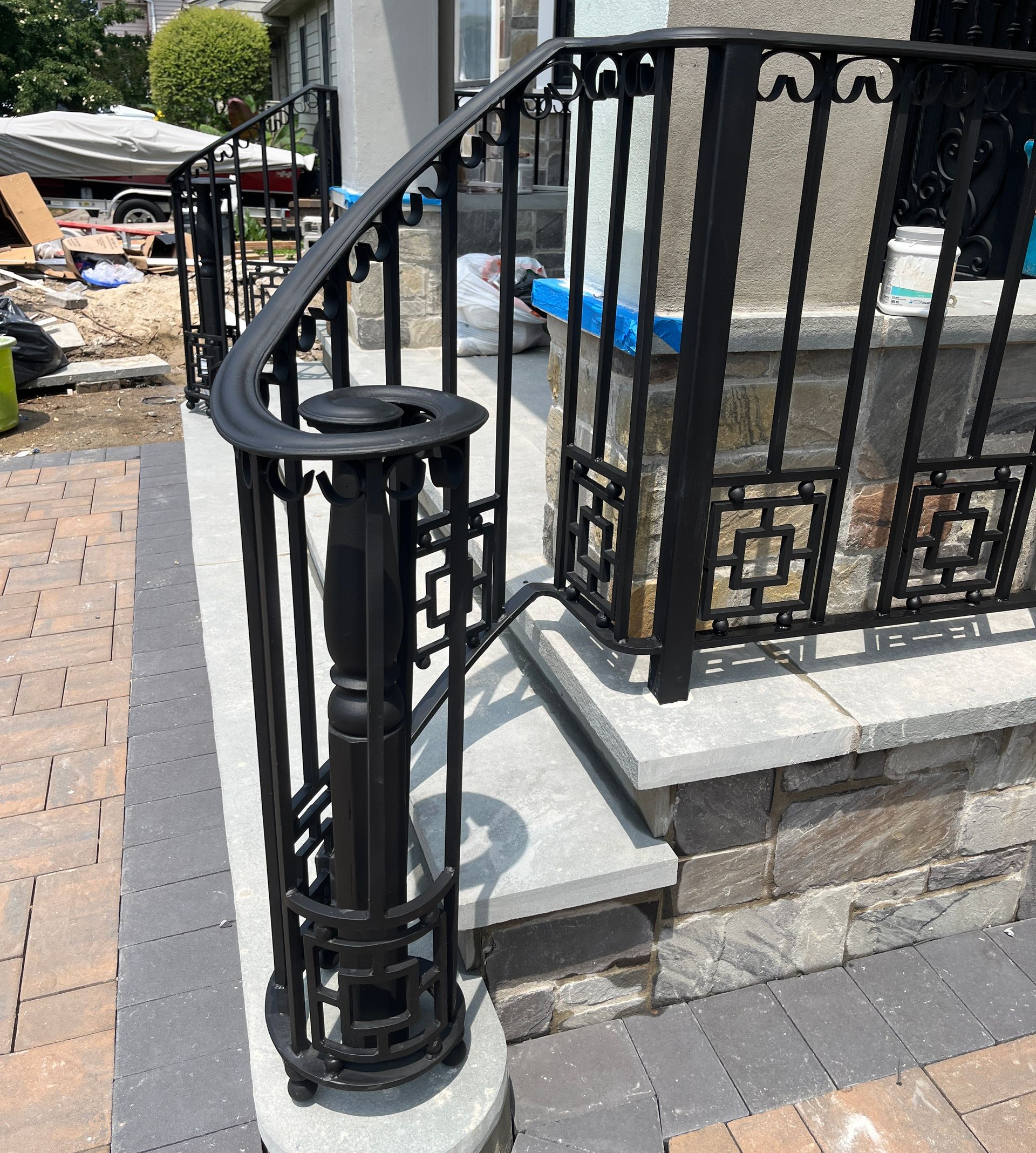 Ornate black wrought iron staircase railing with a wood handrail Ornate black wrought iron staircase railing with a wood handrail