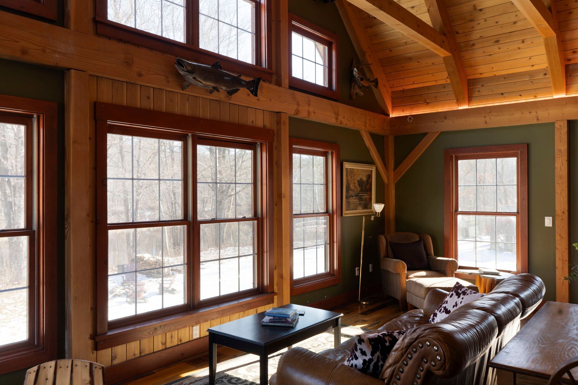 Bathroom with a white square sink on a speckled countertop, green walls, and a large mirror.