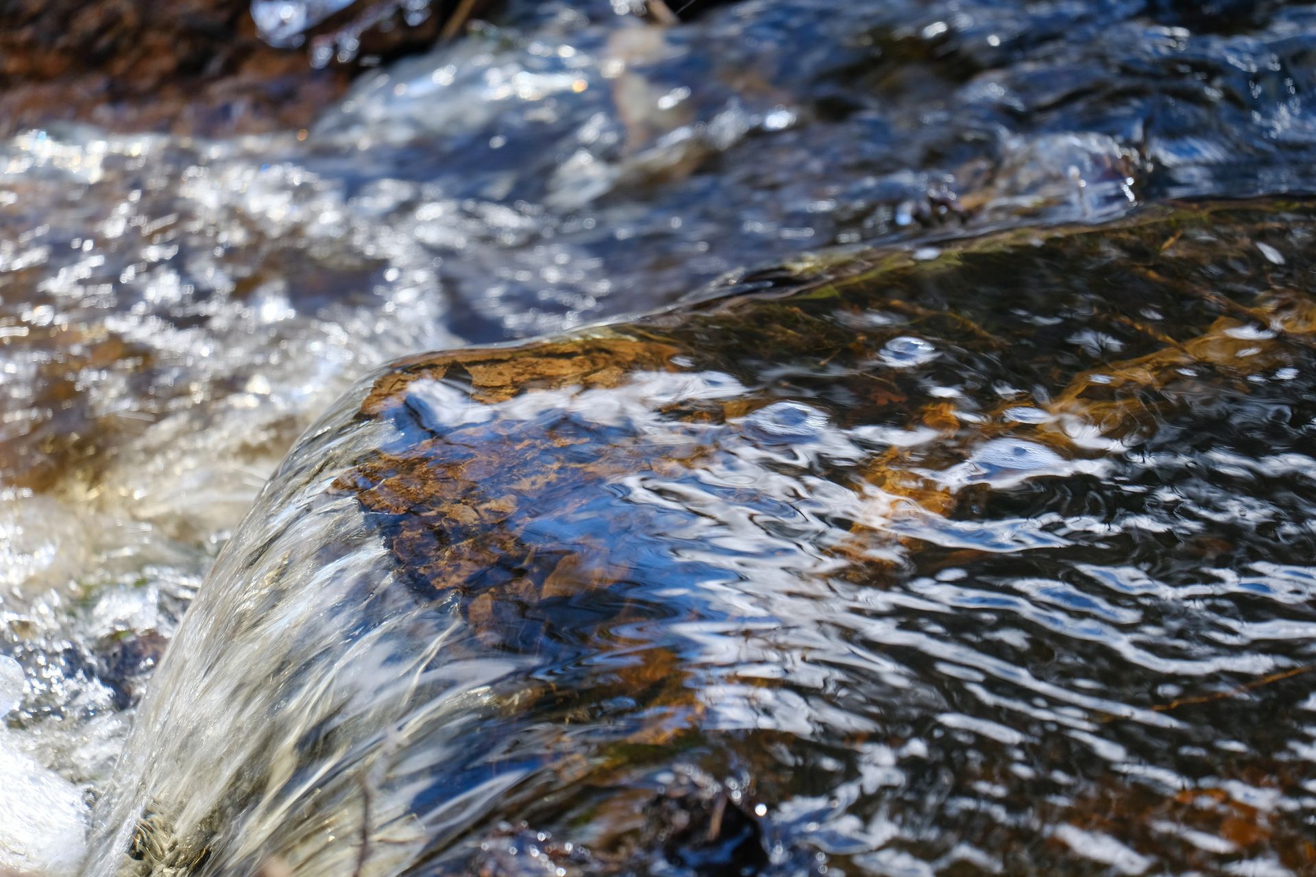 A close up of a stream of water flowing over rocks.